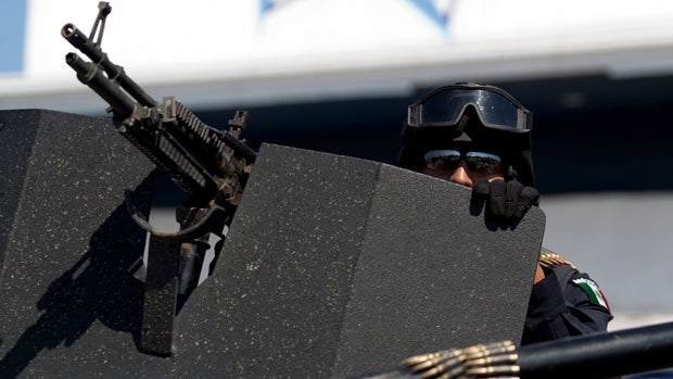 A federal police officer patrols the entrance to Apatzingan, Mexico, Jan. 14, 2014. 