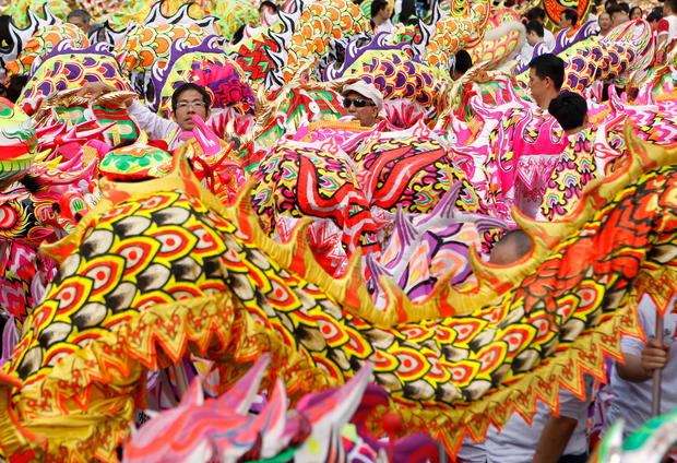Dragon and lion dance performers look on 