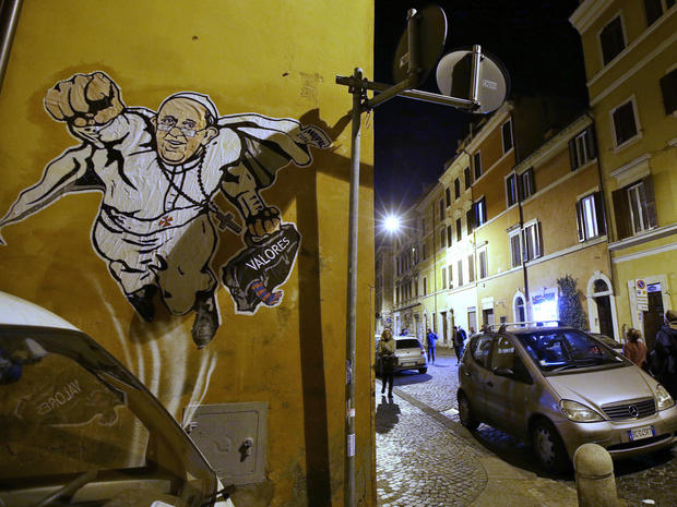 Graffiti depicting Pope Francis as a Superman-like hero, clutching a bag with the Spanish word for "Values," is seen on a wall of the Borgo Pio district near St. Peter's Square 