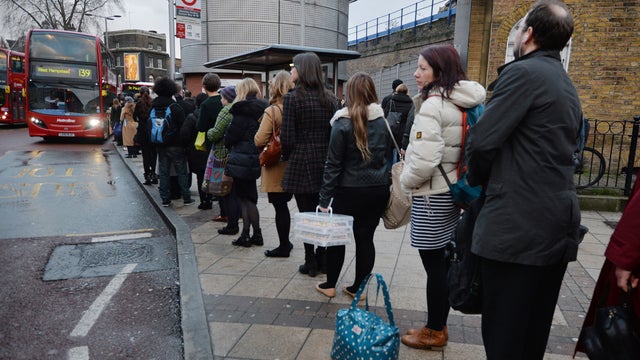 Commuters queue for buses at London's Waterloo station in central London 
