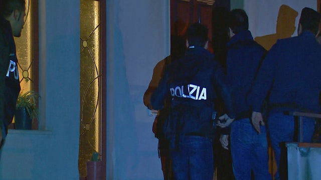 Italian police officers enter a residence near the port city of Goia Tauro during raids targeting members of the 'ndrangheta crime syndicate 