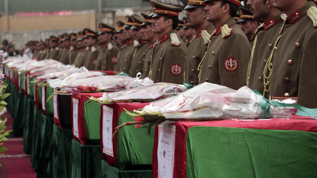 Members of the Honor Guard stand at attention near the caskets of Afghan national army soldiers during a funeral ceremony in Kabul 