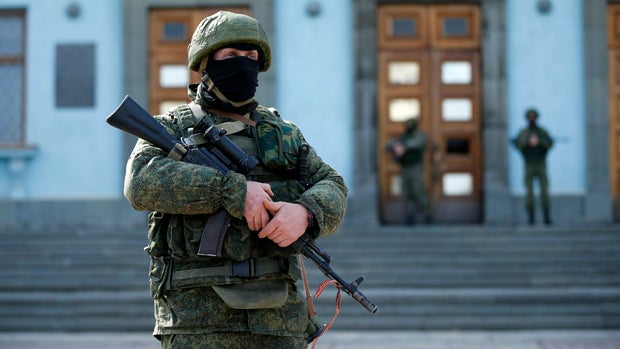 Armed men patrol near the regional administration building in the Crimean city of Simferopol, Ukraine, March 1, 2014. 