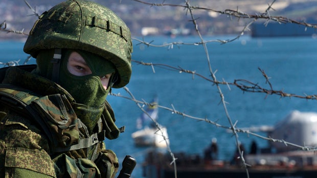 Russian soldiers guard a pier where two Ukrainian naval ships are moored in Sevastopol, Ukraine, March 5, 2014. 