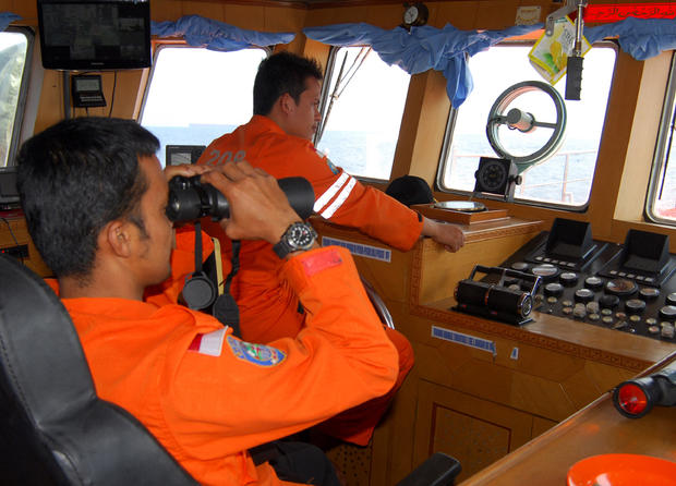 A member of Indonesian National Search And Rescue Agency (BASARNAS) uses binoculars to scan the horizon during a search operation for the missing Malaysia Airlines Boeing 777 