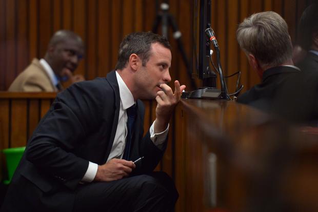 Oscar Pistorius speaks with a member of his legal team prior to a hearing of his trial at the North Gauteng High Court in Pretoria 