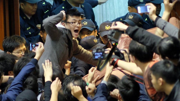 Police officers try to enter the Taiwanese parliament, which is occupied by activists protesting against moves by the ruling Nationalist Party to ratify a contentious trade agreement with China, in Taipei, Taiwan, March 19, 2014. 