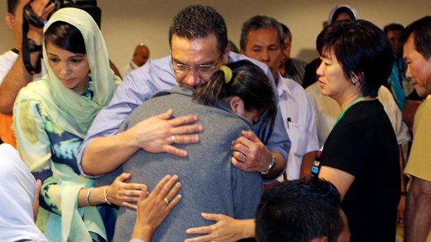 Malaysia's acting Transport Minister Hishammuddin Hussein, center, comforts a relative of passengers on board missing Malaysia Airlines Flight MH370 at a hotel in Putrajaya, Malaysia, March 29, 2014. 