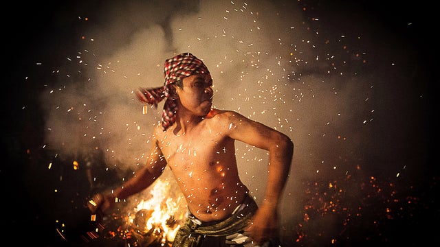 Balinese men play with burning coconut husks to celebrate Nyepi Day 