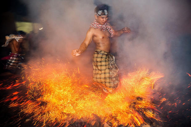 Balinese men play with burning coconut husks to celebrate Nyepi Day 