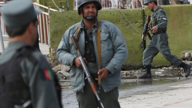 Afghan police block the street after a suicide bomber struck the entrance gate of the Interior Ministry 