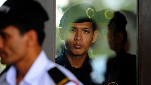 A Malaysia Airlines auxiliary police stands guard inside the hotel lobby while a hotel security person stands guard outside the hotel in Bangi, Malaysia, on the outskirts of Kuala Lumpur, April 1, 2014. 