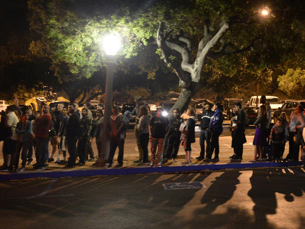People wait in line to board shuttle buses that will transport them to the Griffith Park Observatory to witness the lunar eclipse from Los Angeles 