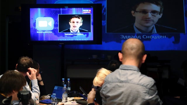Journalists listen to a question posed by former NSA contractor Edward Snowden, at a media center during Russian President Vladimir Putin's live broadcast 