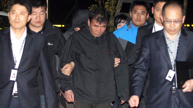 Lee Joon-seok, 68, center, captain of the South Korean ferry Sewol, which capsized Wednesday, arrives at a court in Mokpo, April 18, 2014 
