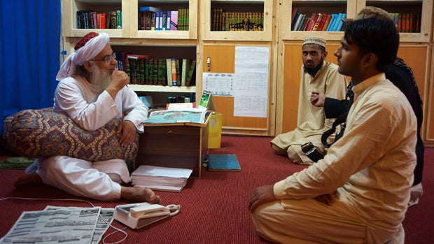 Maulana Abdul Aziz, left, head cleric of a Pakistani seminary, talks to visitor in a library named after slain al Qaeda leader Osama bin Laden April 18, 2014, in Islamabad, Pakistan. 