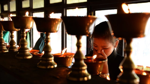 Daughter of Mount Everest avalanche victim Ang Kazi Sherpa light oil lamps at Sherpa Monastery in Kathmandu 