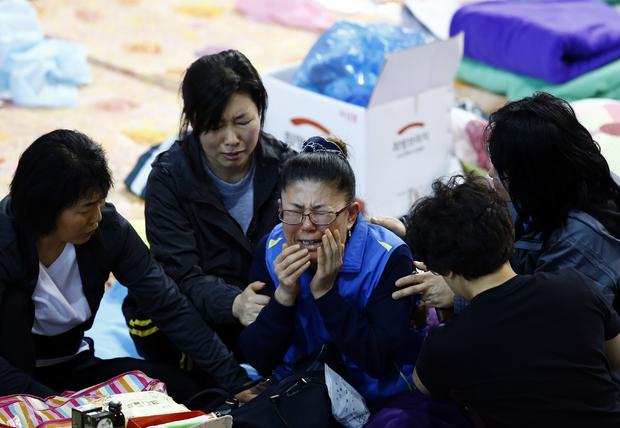 A family member of a missing passenger of capsized passenger ship Sewol which sank last Wednesday, cries after she identified her family member on a list of newly found bodies on a noticeboard at makeshift accommodation at a gymnasium in the port city of Jindo 