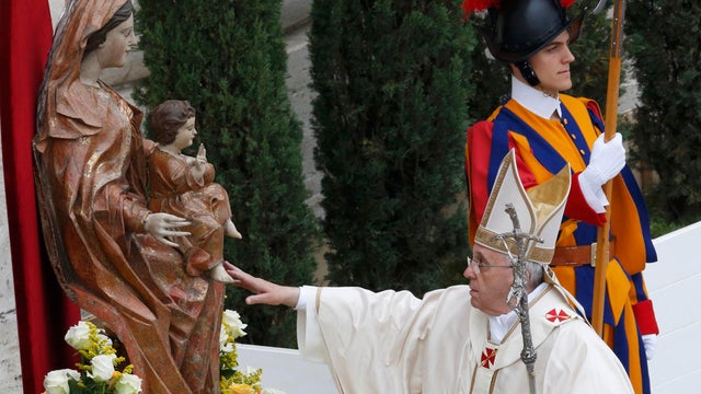 Pope Francis touches the statue of the Virgin Mary as he arrives for the canonization ceremony of Popes John XXIII and John Paul II in St. Peter's Square 
