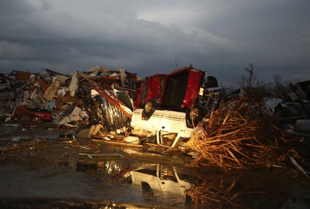 A flipped pickup truck is reflected in water after a tornado destroyed the town of Mayflower, Arkansas 