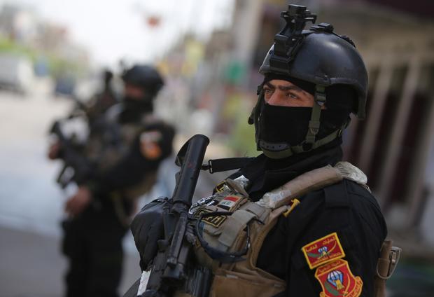 Members of Iraq's anti-terrorism force stand guard outside a polling station in Baghdad 