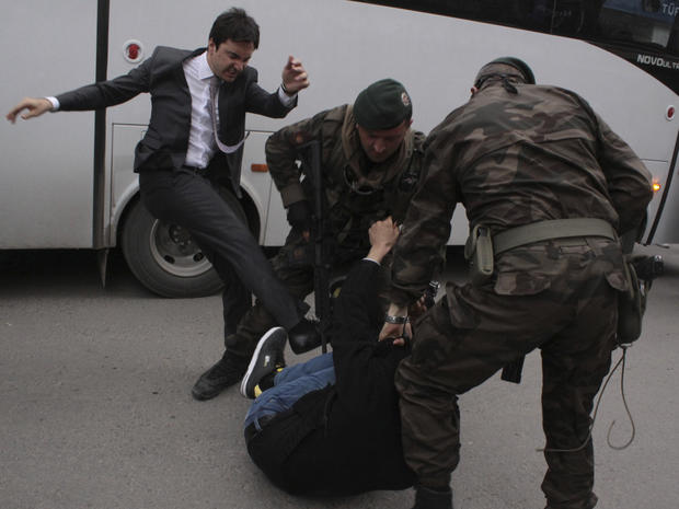 A protester is kicked by Yusuf Yerkel (L), advisor to Turkey's Prime Minister Tayyip Erdogan, as Special Forces police officers detain him during a protest against Erdogan's visit to Soma, a district in Turkey's western province of Manisa 