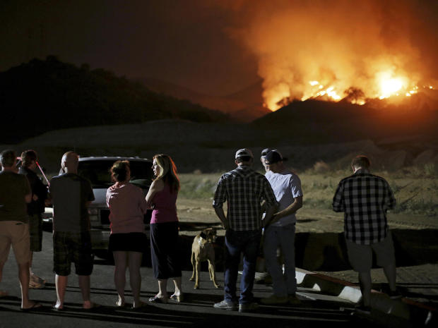 Residents watch a fast-moving wildfire approach in San Marcos, California, May 14, 2014. 