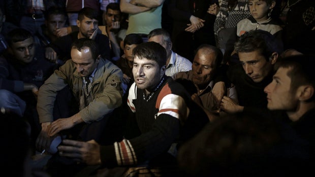 Miner Erdal Bicak, center, speaks to journalists as he joined fellow miners and their family members to commemorate the Soma mine accident victims and protest the government's labor policy in Savastepe , Turkey, May 16, 2014. 