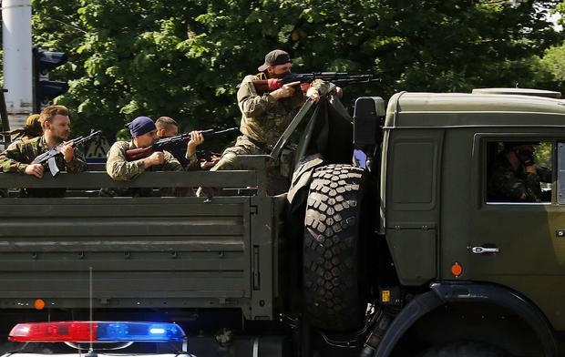 A military truck with armed pro-Russian militants drives through a police check-point toward the airport of the eastern city of Donetsk 