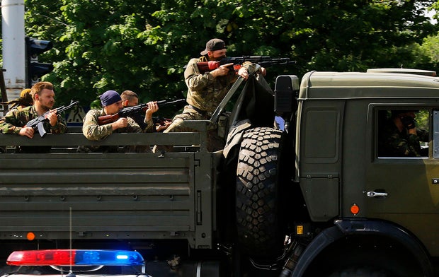 A military truck with armed pro-Russian militants drives through a police check-point towards the airport of the eastern Ukrainian city of Donetsk