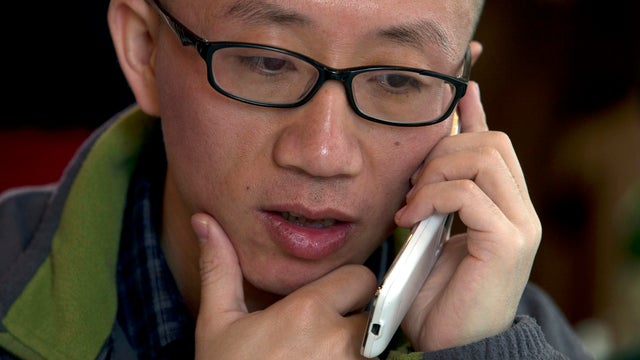 Chinese dissident Hu Jia talks on his phone during a meeting at a restaurant in Beijing, China 