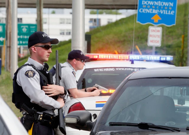 Armed Royal Canadian Mounted Police (RCMP) officers guard exit ramp during hunt for Justin Bourque, who allegedly shot 3 police officers dead and wounded 2 more in Moncton