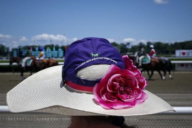 A woman stands on the rail as horses make their way for the third race at Belmont Park before the 2014 Belmont Stakes in Elmont, New York, June 7, 2014. 