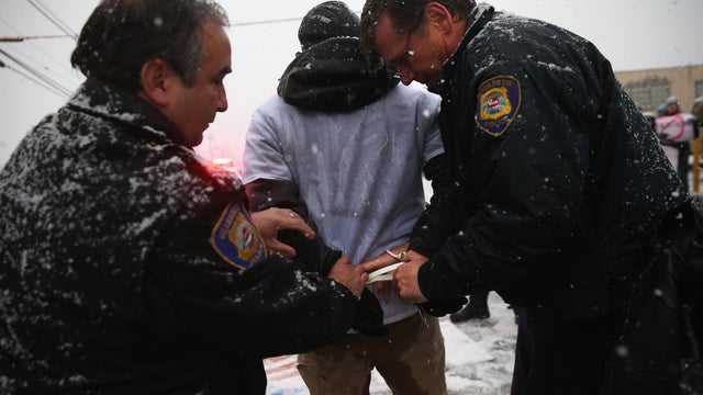 Police arrest protesters blocking the entrance of an immigrant detention center on December 10, 2013 in Elizabeth, New Jersey. 