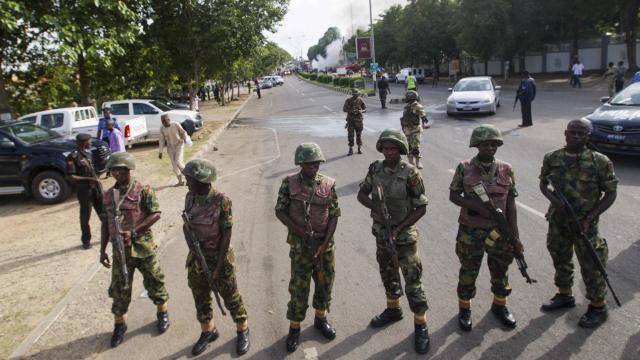 Nigerian army soldiers stand guard as they cordon off a road leading to the scene of a blast at a business district in Abuja 