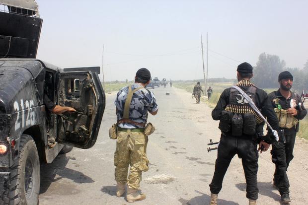 Iraqi security forces and armed volunteers move with military vehicles during clashes with militants of the Islamic State of Iraq and Syria (ISIS), in the town of Dalli Abbas in Diyala province 