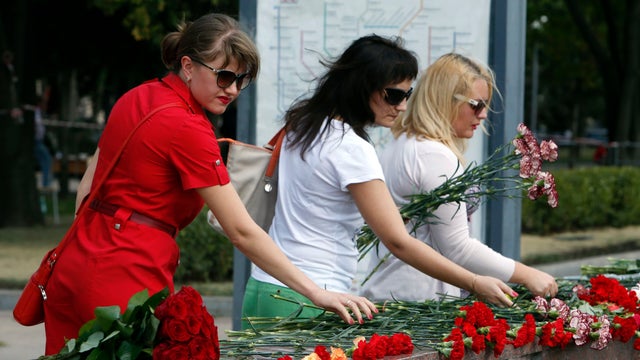 People lay flowers in memory of victims of an accident in which three Moscow subway carriages derailed on a train during morning rush hour 