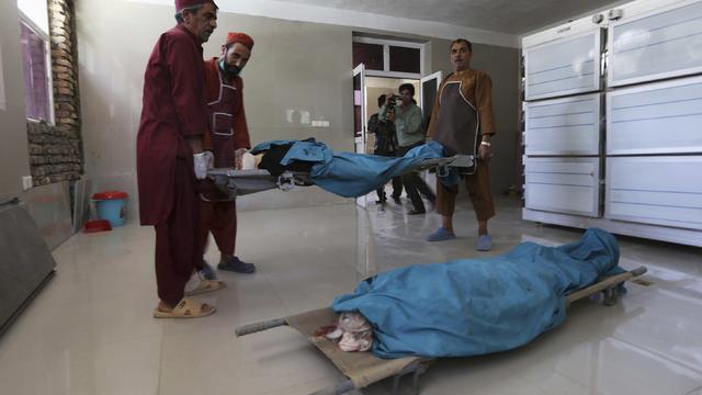 Afghan medical workers carry the bodies of two Finnish women who were shot dead in Herat 