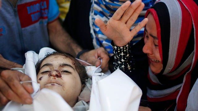 Relatives of Palestinian girl Layan al-Silk, whom medics said was killed with other family members by Israeli shelling at a market in Gaza City's Shijaiyah district, mourn during her funeral 