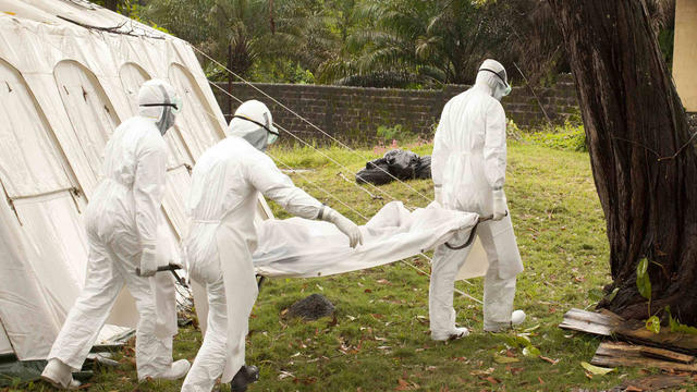 e medical personnel transport a person who died from the Ebola virus at the Case Management Center in Foya, Liberia 