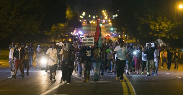 Demonstrators march in street while protesting the shooting death of Michael Brown in Ferguson, Missouri on August 12, 2014 