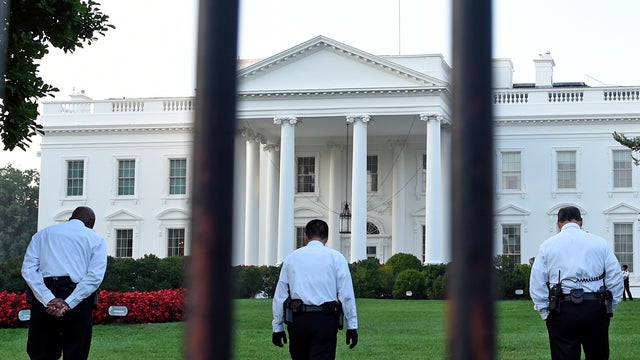 Uniformed Secret Service officers walk along lawn on north side of White House on Sept. 20, 2014 