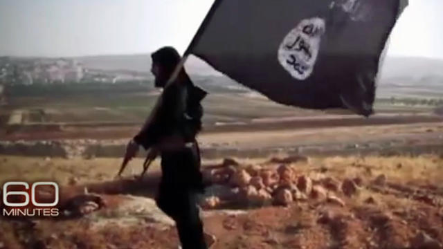 ​An ISIS militant carries the group's flag 