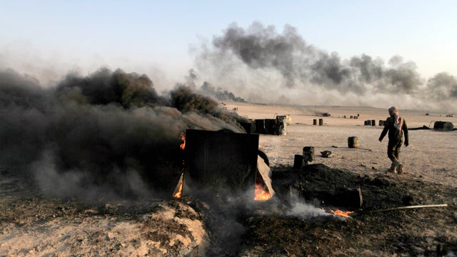 A man walks at a makeshift oil refinery site in al-Mansoura village in Raqqa's countryside 