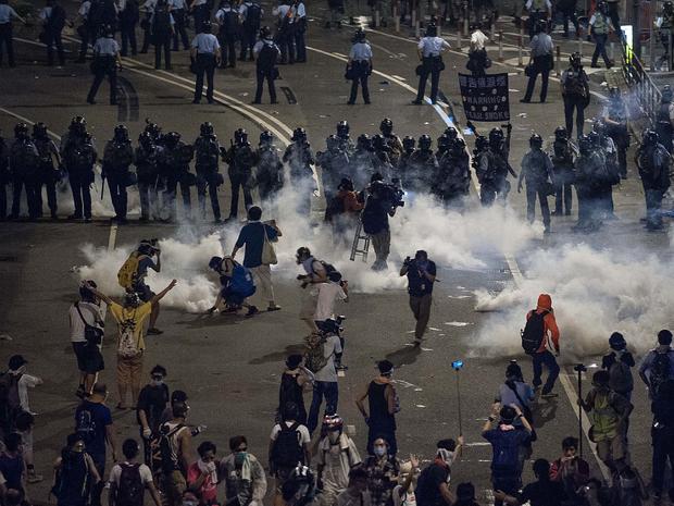 Demonstrators disperse as tear gas is fired by police during a protest 