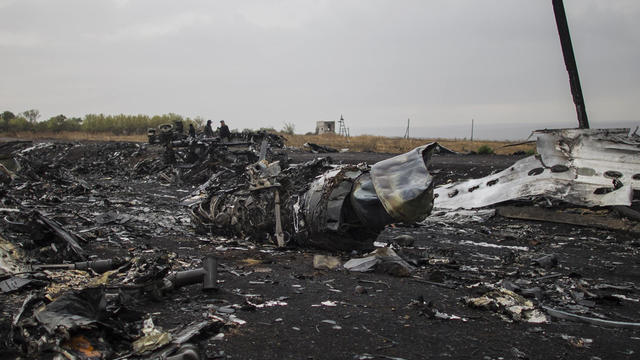 People stand near the remains of fuselage where the downed Malaysia Airlines flight MH17 crashed, near the village of Grabovo, in Donetsk region 
