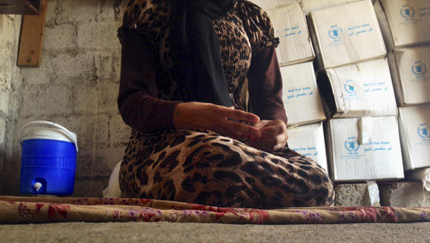 A 15-year-old Yazidi girl captured by the Islamic State of Iraq and Syria group and forcibly married to a militant in Syria sits on the floor of a one-room house she now shares with her family while speaking in an interview with The Associated Press in Ma 