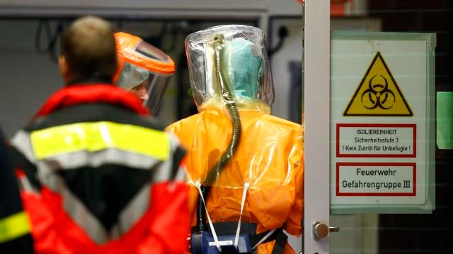 Members of medical staff in sealed protective suits work as an Ebola patient arrives at the University Hospital Frankfurt 