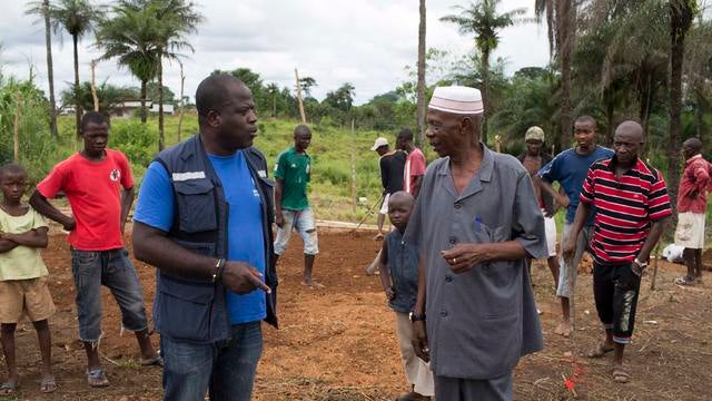 Kande-Bure Kamara from WHO speaks with community leaders at the construction site of a Ebola Care Unit in Kamasondo Village, Port Loko District, Liberia 