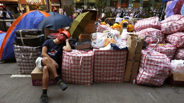 A pro-democracy protester sleeps beside supplies at a make-shift logistic centre on the blocked Nathan Road at Mongkok shopping district in Hong Kong 